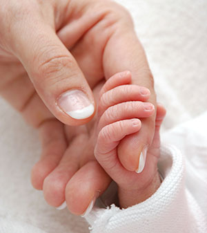 Babyhand umklammert einen Finger